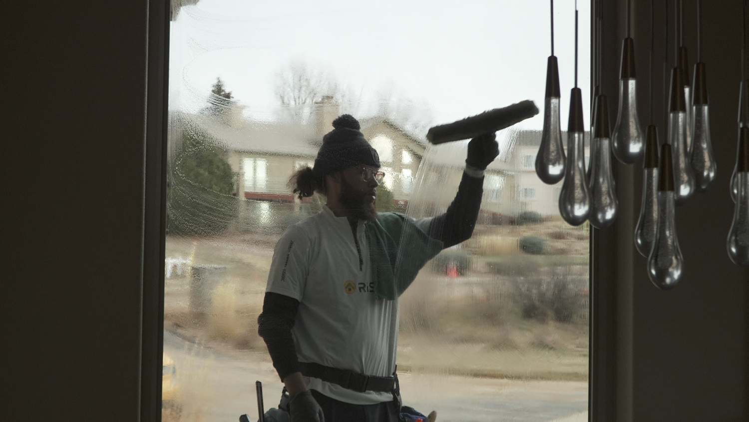 A Rise technician cleaning an interior window